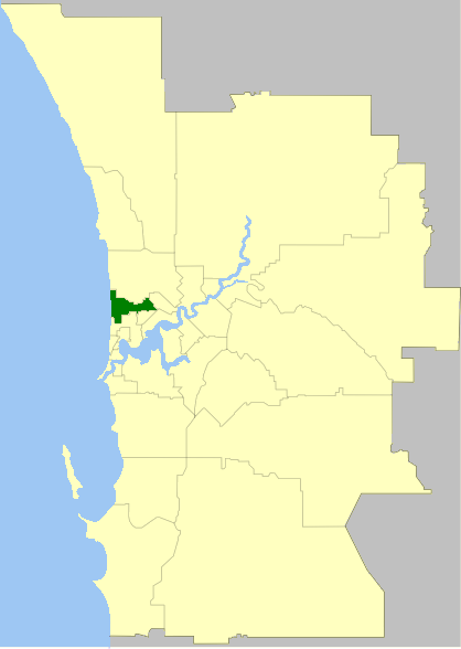 A map highlighting a specific area in dark green within a larger yellow region, bordered by a gray area and a blue water body on the left side.