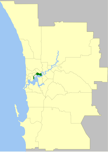 Map highlighting a specific district in green within a larger outlined area. The larger area is adjacent to a body of water on the left side of the map.