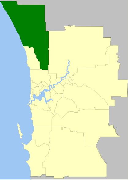 A map marking a specific area in dark green within a larger light yellow region. Blue lines likely represent bodies of water. The green area is located in the northwestern part of the larger region.